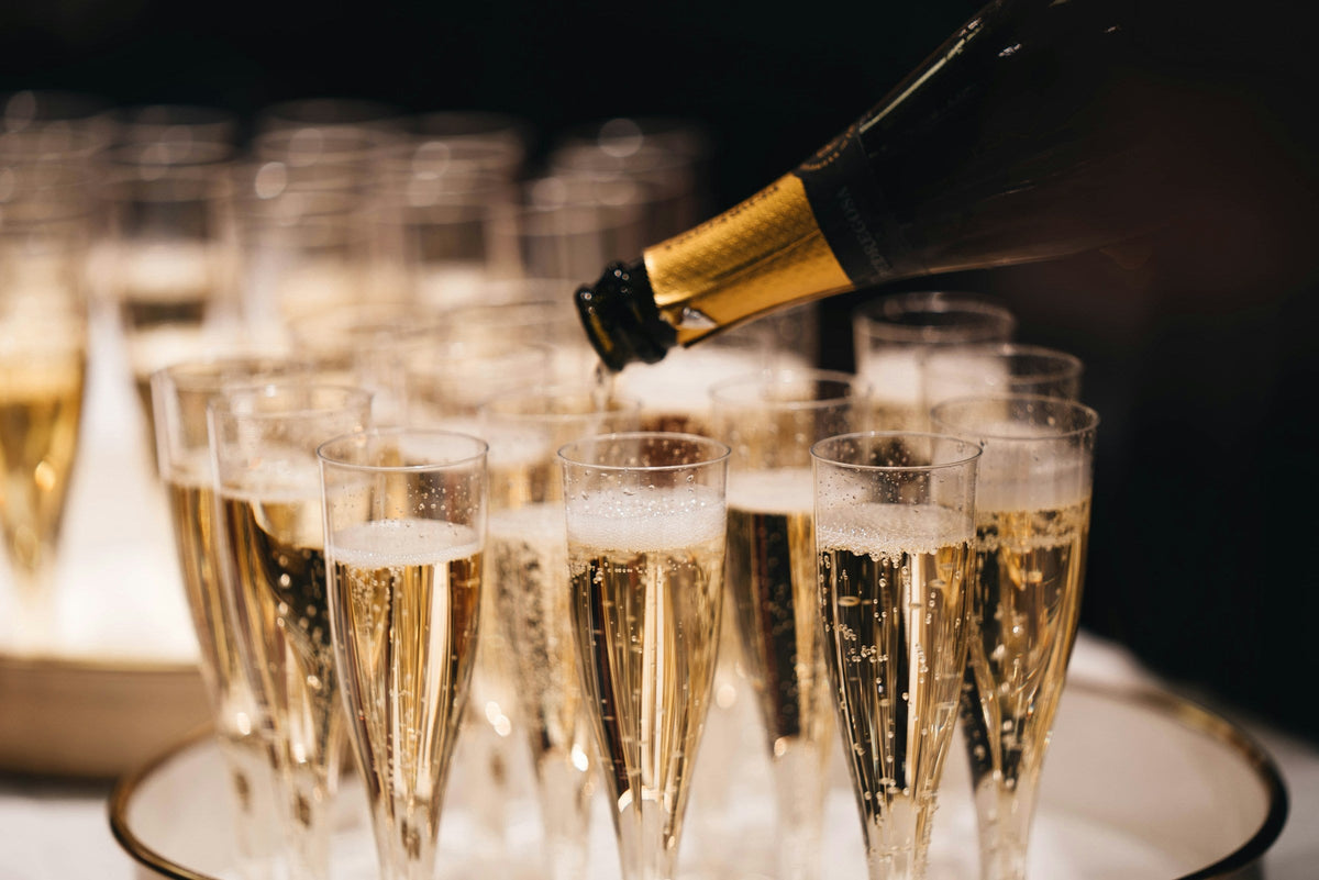 Flûtes de champagne levées pour un toast – Maison Mouche